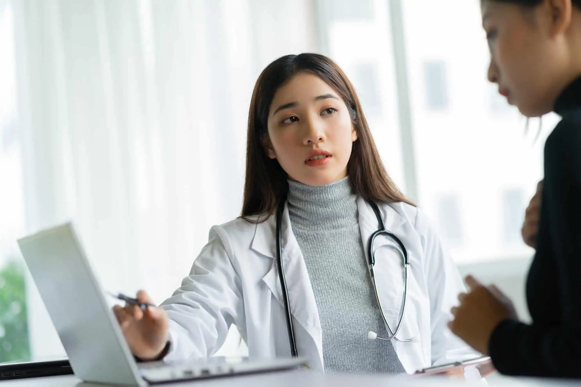 Asian Femal Gynocologist Talking to Patient