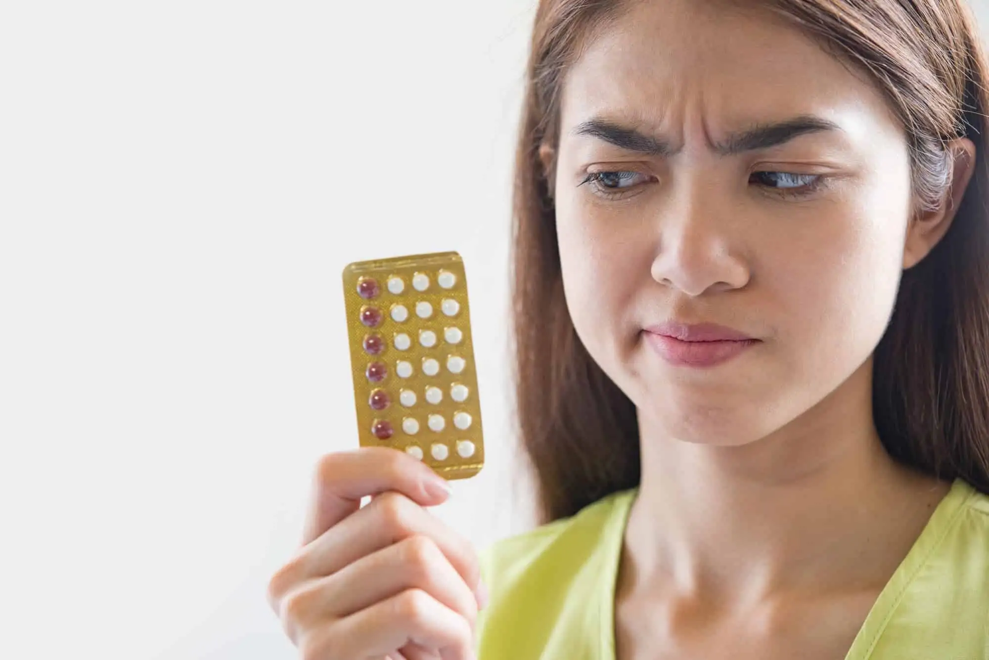 Woman holding birth control pills